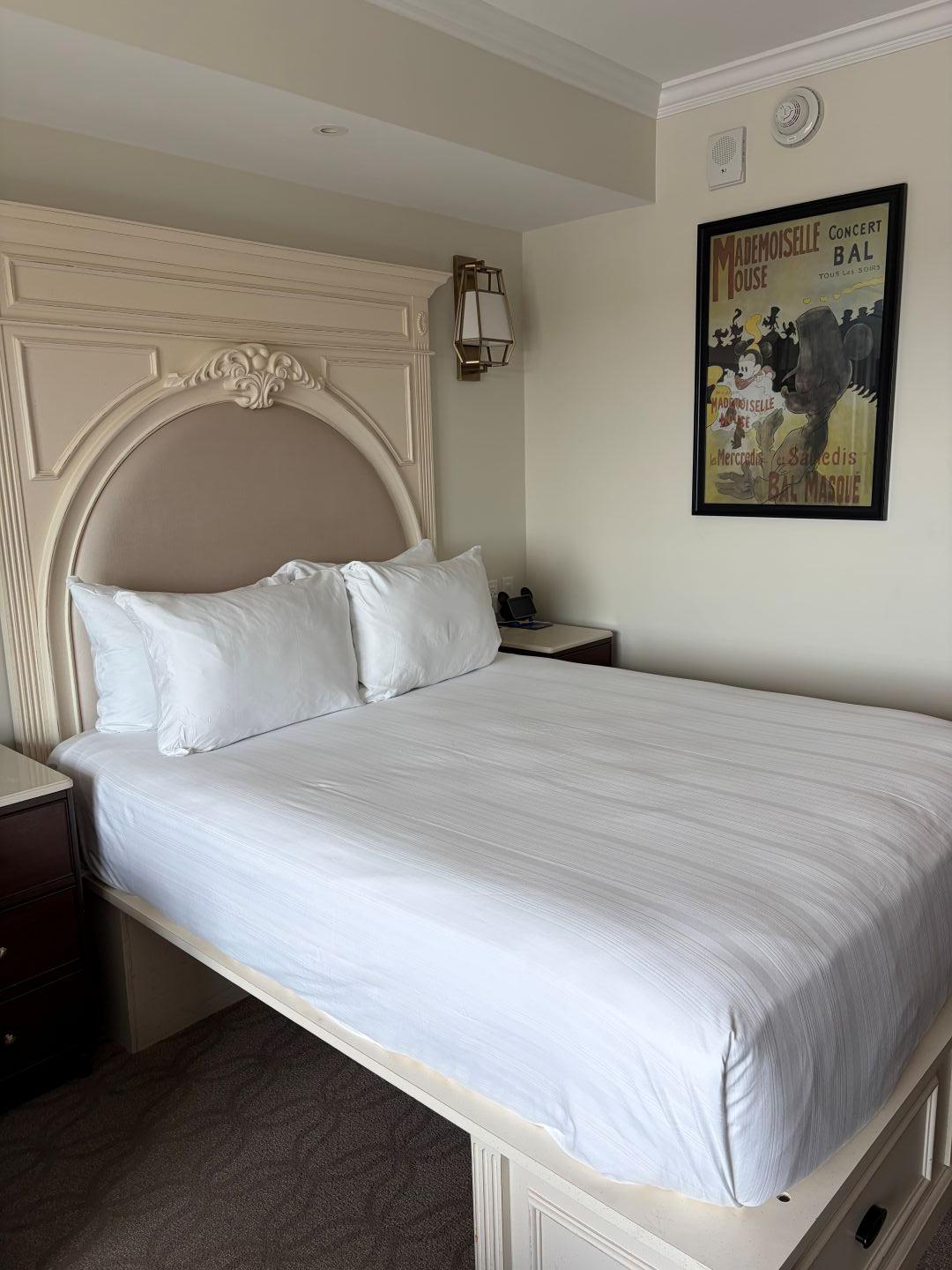 Hotel room with a queen sized bed, and pictures on the wall