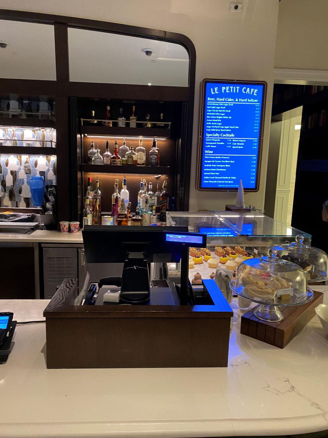 A register, menu, and snacks at a coffee bar