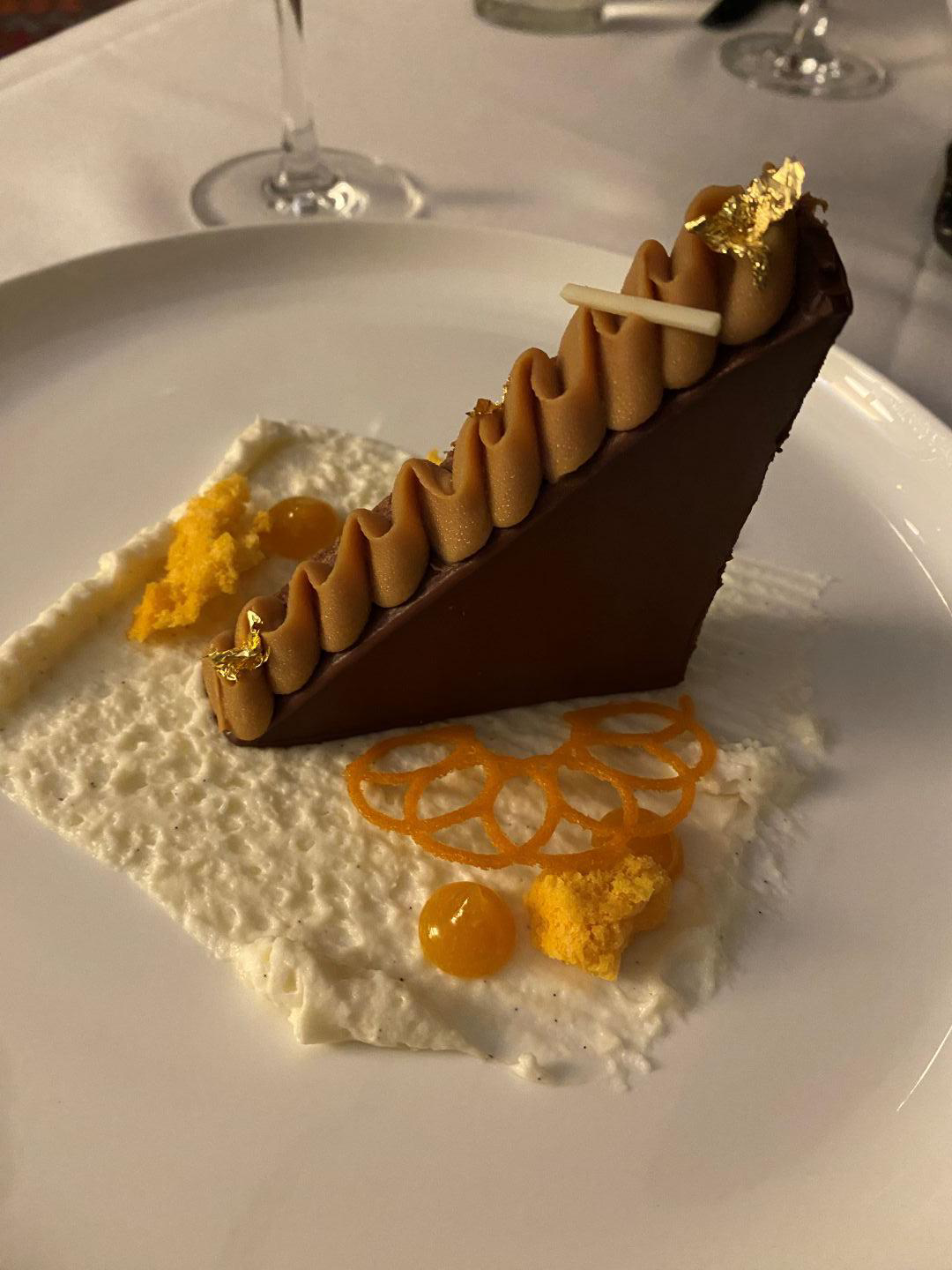 Chocolate cake slice on a plate. It is decorated with accompaniments