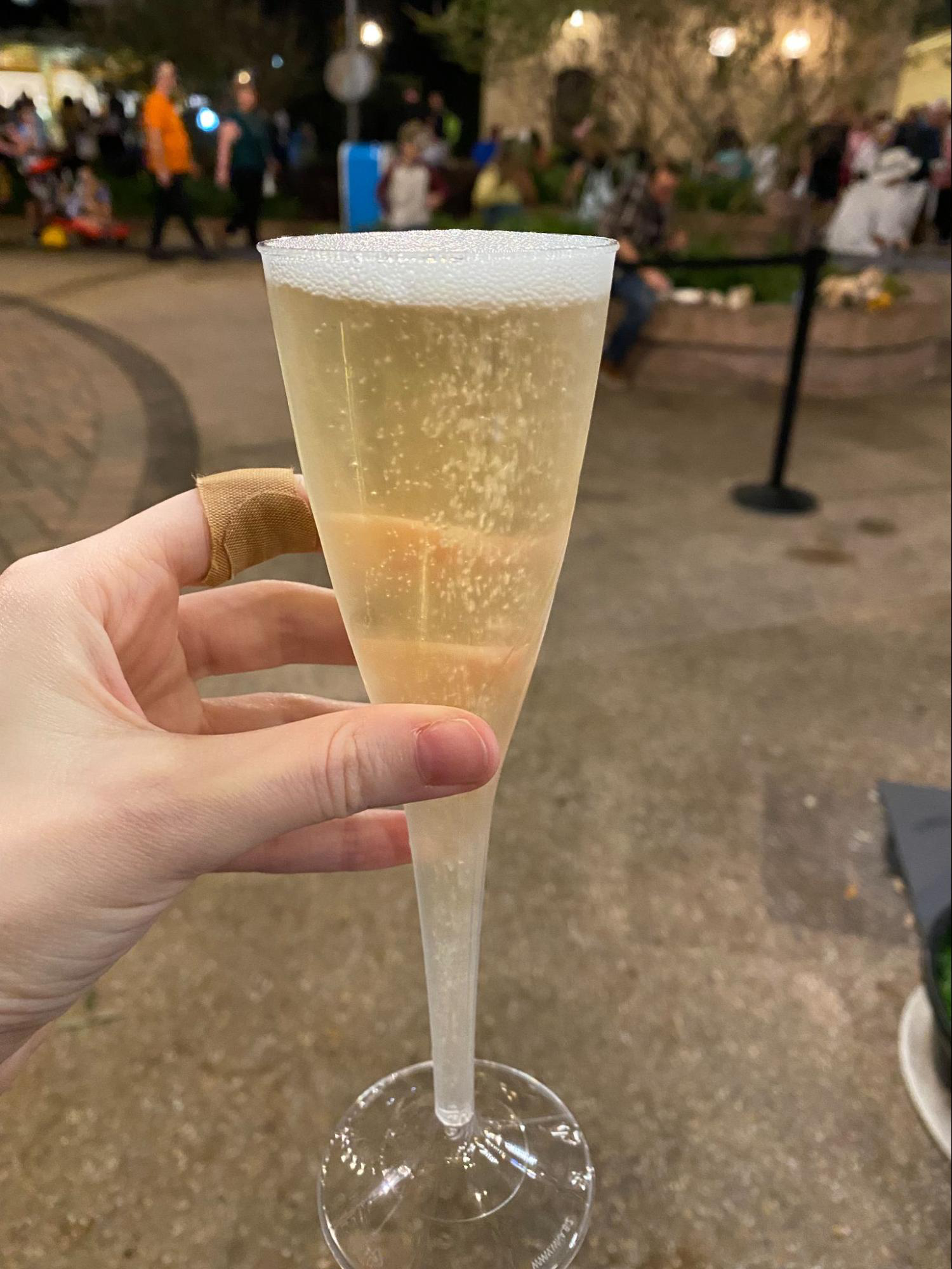 A photo of a hand holding a plastic champagne flute