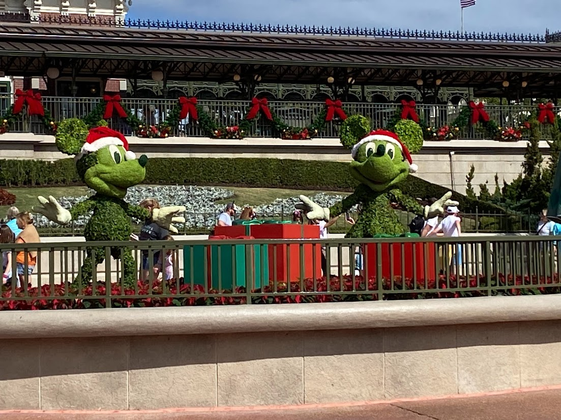 A photo of Mickey and Minnie topiaries in front of Magic Kingdom